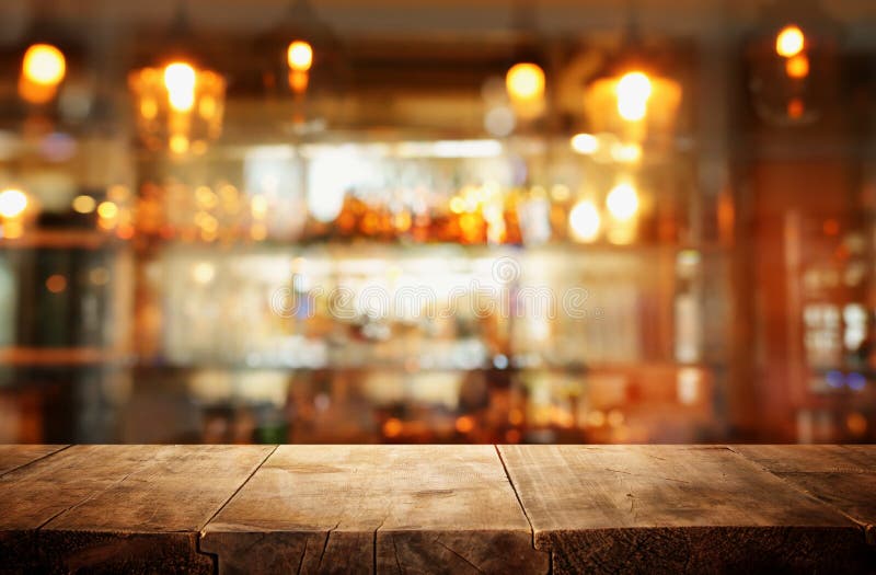 Image of Wooden Table in Front of Abstract Blurred Restaurant Lights Background Stock Photo