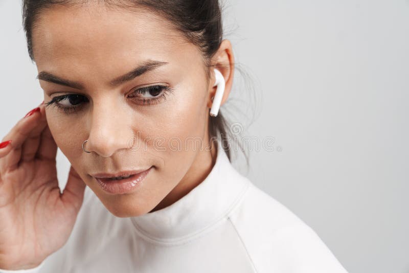 Image of brunette woman in sportswear putting on earpods isolated over gray background stock photography Image of brunette woman in sportswear putting on earpods isolated over gray background stock photography