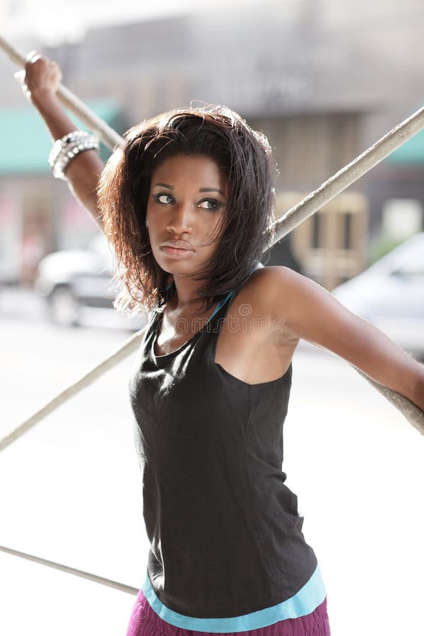 Image of a young woman posing by scaffolding