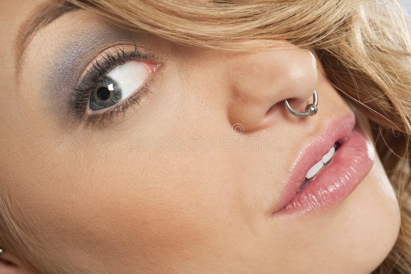 Imagem colhida da jovem mulher bonita com o anel de nariz que olha lateralmente