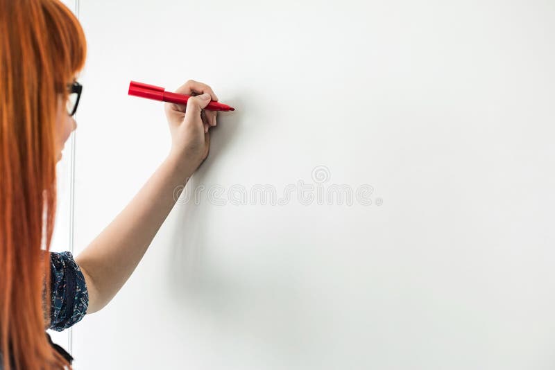 Imagem colhida das mulheres de negócios que escrevem no whiteboard no escritório criativo
