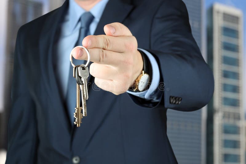 A imagem colhida do agente imobiliário que dá a casa fecha fora foto de stock A imagem colhida do agente imobiliário que dá a casa fecha fora foto de stock
