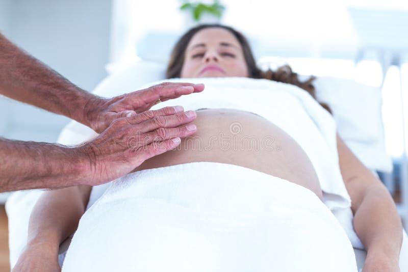 Imagem colhida do massagista que faz massagens a mulher gravida fotos de stock Imagem colhida do massagista que faz massagens a mulher gravida fotos de stock