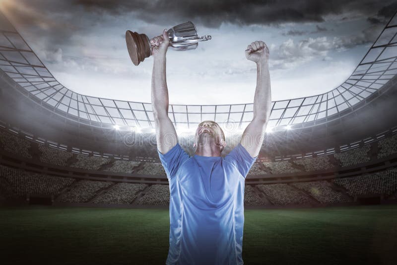 Imagem composta 3D do jogador feliz do rugby que guarda o troféu fotografia de stock Imagem composta 3D do jogador feliz do rugby que guarda o troféu fotografia de stock