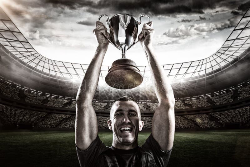 Imagem composta 3D do retrato do jogador bem sucedido do rugby que guarda o troféu imagens de stock Imagem composta 3D do retrato do jogador bem sucedido do rugby que guarda o troféu imagens de stock