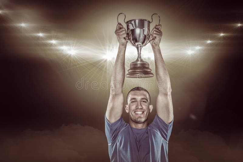 Imagem composta 3D do retrato do jogador de sorriso do rugby que guarda o troféu fotos de stock Imagem composta 3D do retrato do jogador de sorriso do rugby que guarda o troféu fotos de stock