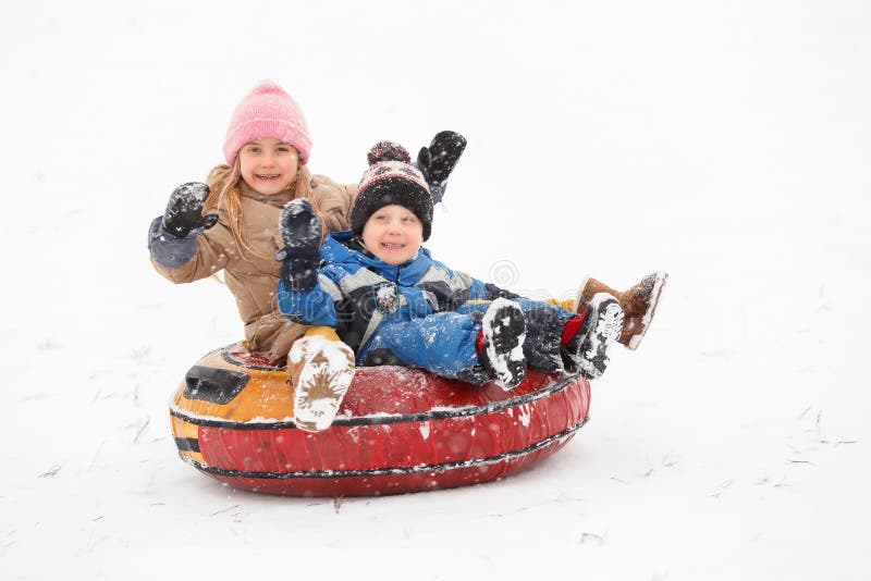 Imagem da tubulação alegre da equitação da menina e do menino imagens de stock Imagem da tubulação alegre da equitação da menina e do menino imagens de stock