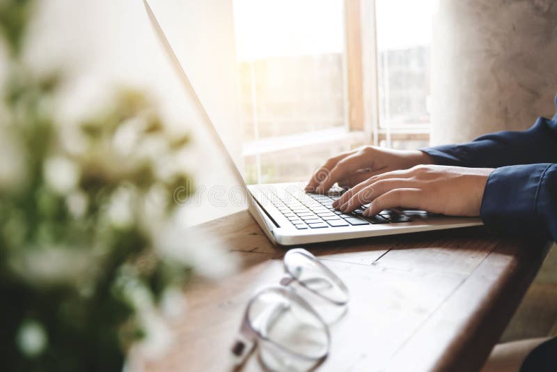 Imagem da utilização das mãos da mulher/que datilografa no foco selecionado por computador do portátil no teclado Imagem da utilização das mãos da mulher/que datilografa no foco selecionado por computador do portátil no teclado