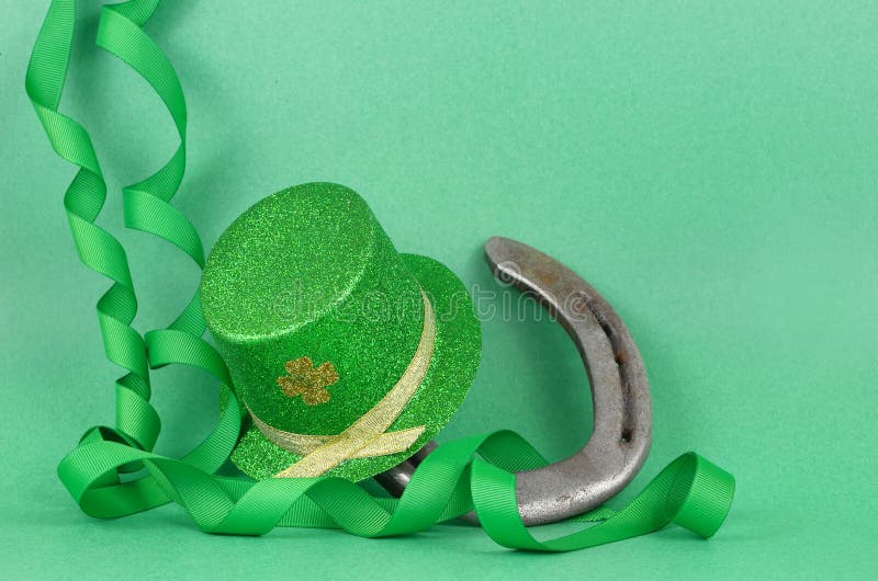 Imagem do dia de St Patrick do chapéu sparkly do duende do verde e do ouro com as ondas do verde e fita do ouro em um fundo verde foto de stock royalty free Imagem do dia de St Patrick do chapéu sparkly do duende do verde e do ouro com as ondas do verde e fita do ouro em um fundo verde foto de stock royalty free