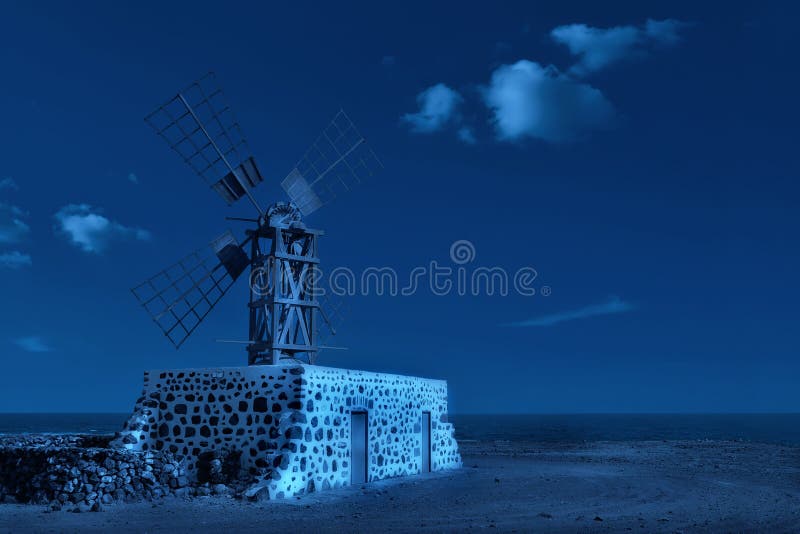 Imagem em tons monocromáticos azul clássico de moinho tradicional à noite com lua pelo oceano Fuerteventura, Ilhas Canárias, imagens de stock royalty free Imagem em tons monocromáticos azul clássico de moinho tradicional à noite com lua pelo oceano Fuerteventura, Ilhas Canárias, imagens de stock royalty free