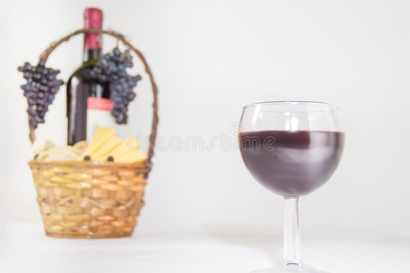 Imagen abstracta de un vidrio de vino Una botella de vino rojo, de uvas y de cesta de la comida campestre con las rebanadas del q imagenes de archivo Imagen abstracta de un vidrio de vino Una botella de vino rojo, de uvas y de cesta de la comida campestre con las rebanadas del q imagenes de archivo