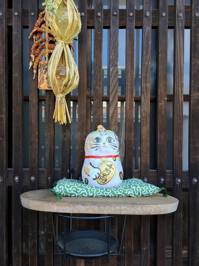 Imagen ascendente cercana de un pequeño gato japonés como la estatua de la porcelana fotografía de archivo Imagen ascendente cercana de un pequeño gato japonés como la estatua de la porcelana fotografía de archivo