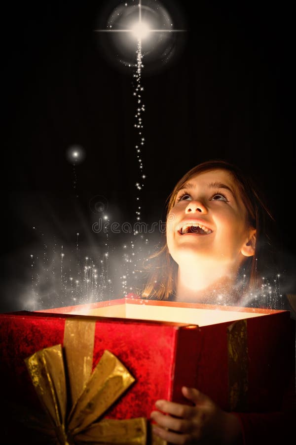 Imagen compuesta de la niña que abre un regalo mágico de la Navidad imágenes de archivo libres de regalías Imagen compuesta de la niña que abre un regalo mágico de la Navidad imágenes de archivo libres de regalías