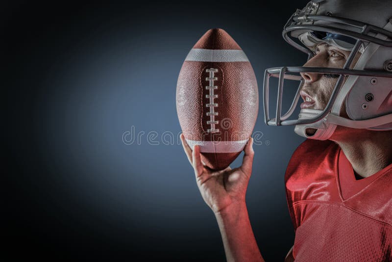 Imagen compuesta del deportista que mira para arriba mientras que lleva a cabo fútbol americano imagen de archivo libre de regalías Imagen compuesta del deportista que mira para arriba mientras que lleva a cabo fútbol americano imagen de archivo libre de regalías