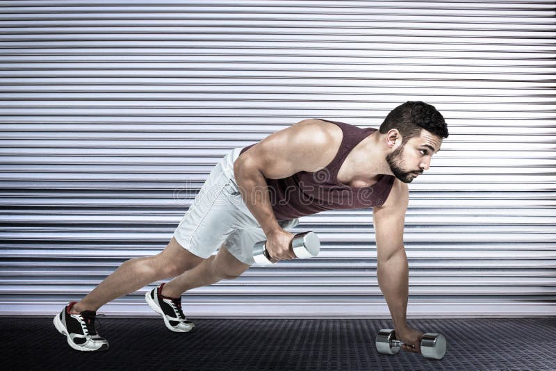 Imagen compuesta del hombre muscular que hace pectorales con pesas de gimnasia foto de archivo libre de regalías Imagen compuesta del hombre muscular que hace pectorales con pesas de gimnasia foto de archivo libre de regalías