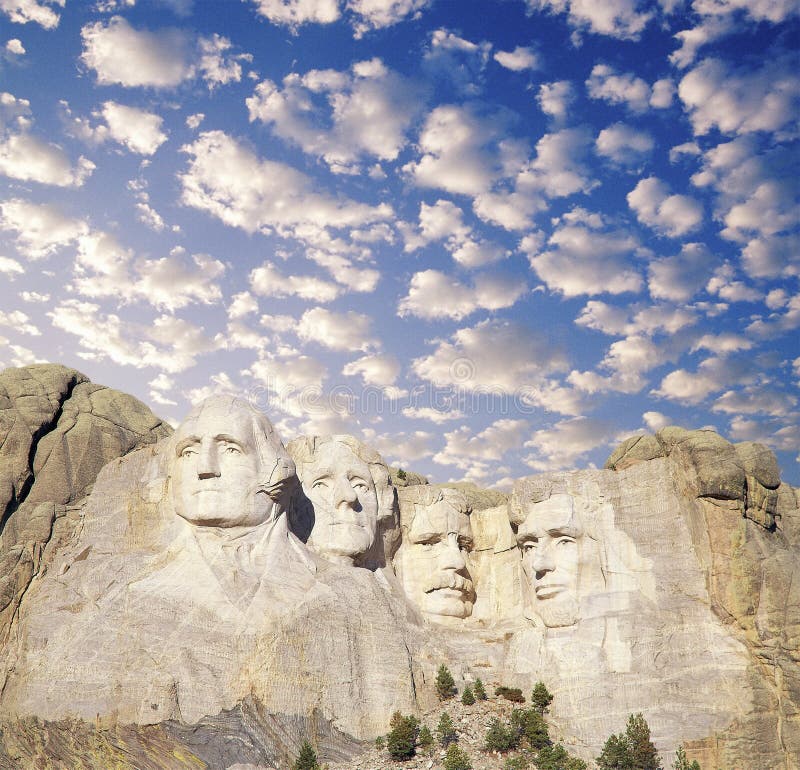 Composite image of Mount Rushmore and blue sky with white puffy clouds. Composite image of Mount Rushmore and blue sky with white puffy clouds