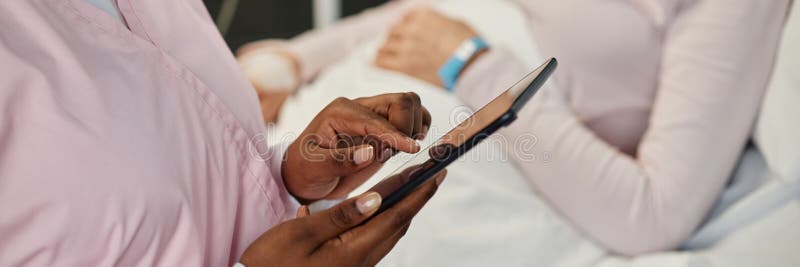 Imagen de cabecera de un experto médico que utiliza un dispositivo de Tablet PC para el cuidado del paciente fotografía de archivo