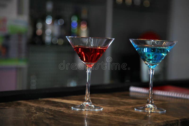 Imagen de dos vidrios de martini llenados de los cócteles que se colocan en el contador de la barra imagen de archivo libre de regalías Imagen de dos vidrios de martini llenados de los cócteles que se colocan en el contador de la barra imagen de archivo libre de regalías