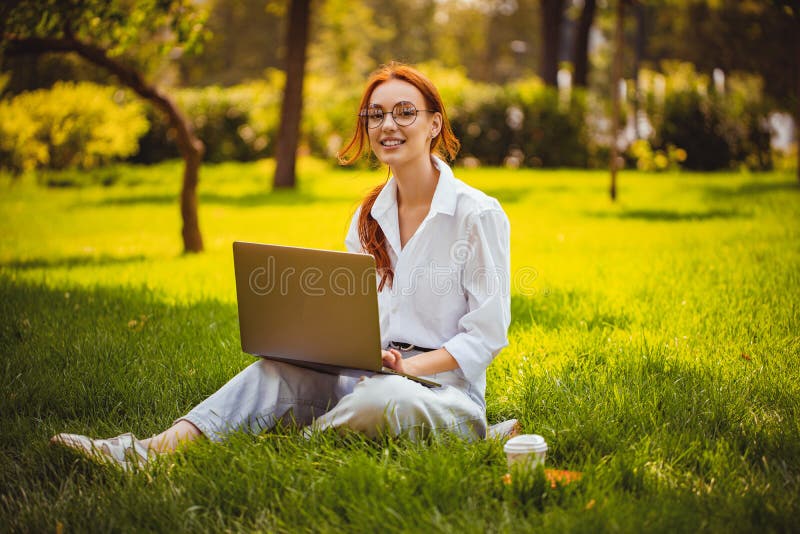 Imagen de hermosa joven y bonita mujer en parque al aire libre usa laptop pc. concepto de educación. independiente foto de archivo