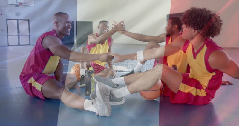 Imagen de la bandera de francia sobre diversos jugadores de baloncesto en la cancha fotos de archivo