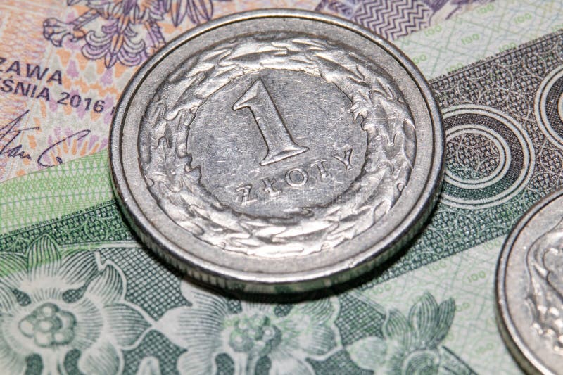 Imagen de macro de una moneda polaca colgada en un billete. imagen de archivo