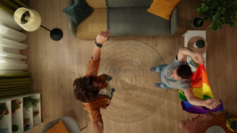 Imagen de primera plana de una pareja homosexual bisexual pansexual transexual saltando bailando en medio de la habitación