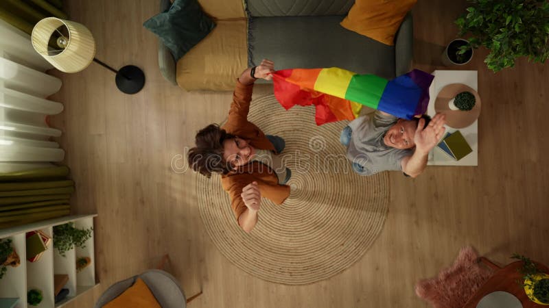 Imagen de primera plana de una pareja homosexual bisexual pansexual transexual saltando en medio de la habitación mirando hacia ar