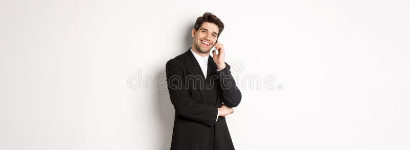 Imagen de un buen hombre de negocios hablando por teléfono sonriente complacido en el traje contra fondo blanco imágenes de archivo libres de regalías