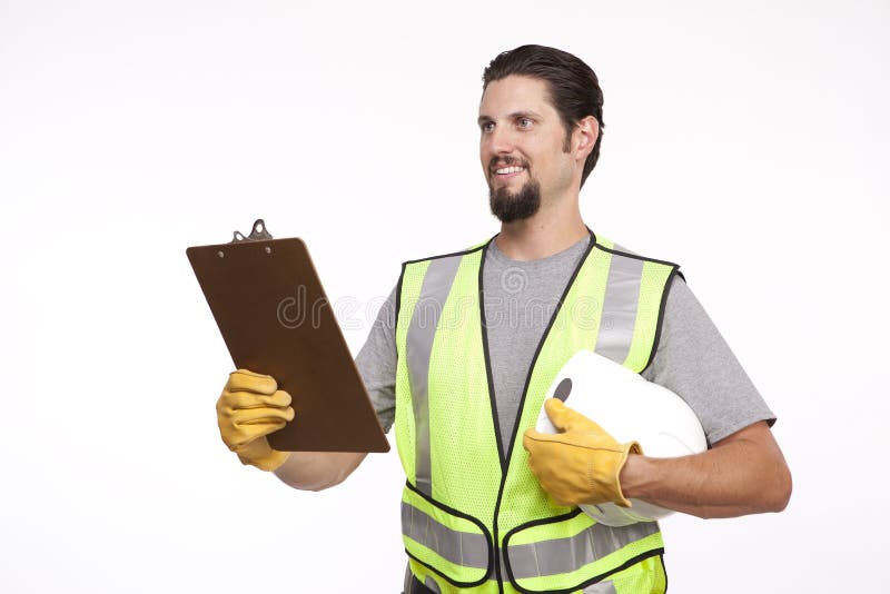 Imagen de un trabajador de construcción con un tablero y un casco de protección fotos de archivo Imagen de un trabajador de construcción con un tablero y un casco de protección fotos de archivo