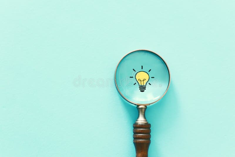 Business concept image. Magnifying glass and lamp. Finding the best idea and inspiration among others. Business concept image. Magnifying glass and lamp. Finding the best idea and inspiration among others.