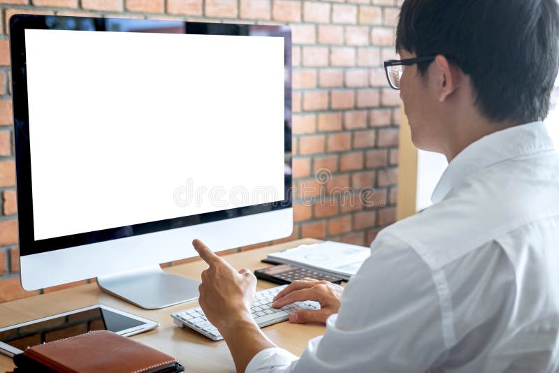 Imagen del hombre joven que trabaja delante del ordenador portátil del ordenador que mira la pantalla con una pantalla blanca lim imagen de archivo libre de regalías Imagen del hombre joven que trabaja delante del ordenador portátil del ordenador que mira la pantalla con una pantalla blanca lim imagen de archivo libre de regalías