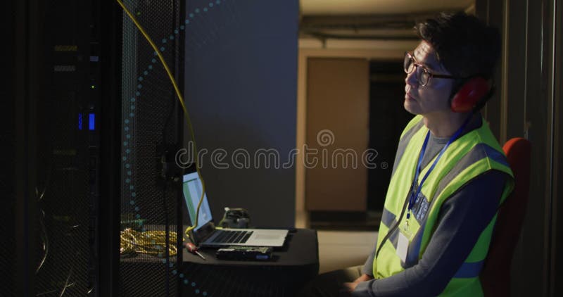 Imagen del padlock digital sobre un hombre asiático que trabaja con un portátil en una sala de servidores. seguridad de datos de red y concepto de seguridad digital de imágenes generadas digitalmente