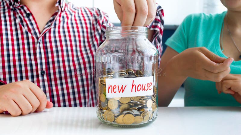 Imagen del primer del dinero joven del ahorro de la familia para comprar la nueva casa fotos de archivo libres de regalías Imagen del primer del dinero joven del ahorro de la familia para comprar la nueva casa fotos de archivo libres de regalías