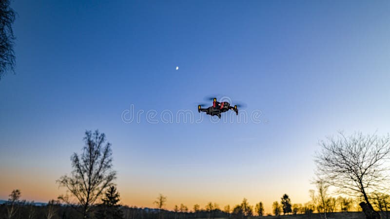 A low angle shot of a drone under the beautiful sunset sky. A low angle shot of a drone under the beautiful sunset sky