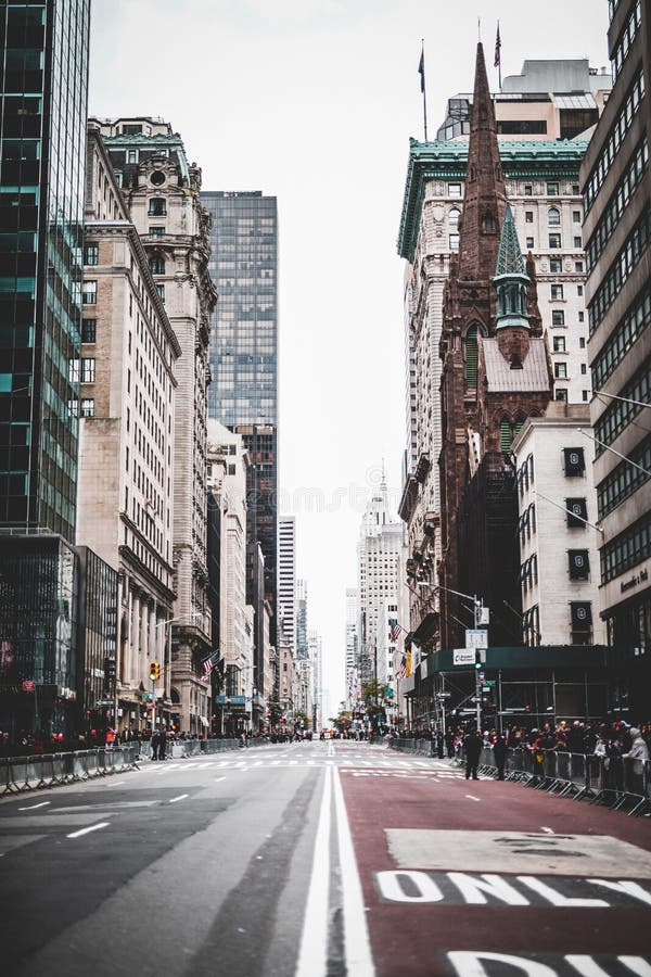 Imagen vertical en ángulo bajo de una calle de la ciudad con edificios modernos e históricos en ambos lados. imagen de archivo