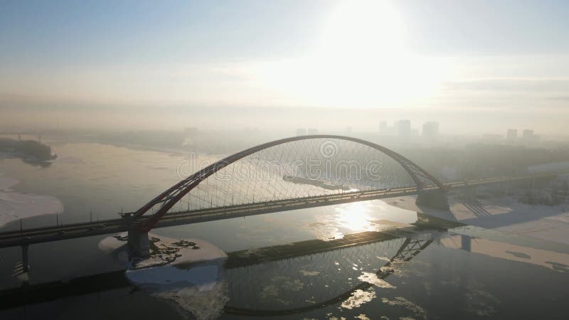 Imagens aéreas de uma grande ponte sobre um rio de inverno. ponte de bugrinsky em novosibirsk 4k