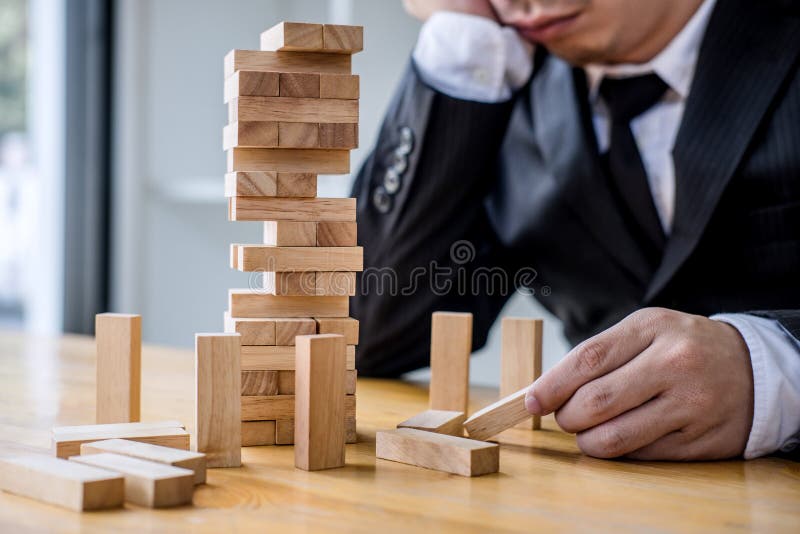 Images de la main des hommes d'affaires pla?ant et tirant le bloc en bois sur la tour, le concept alternatif de risque, le plan e photo libre de droits Images de la main des hommes d'affaires pla?ant et tirant le bloc en bois sur la tour, le concept alternatif de risque, le plan e photo libre de droits
