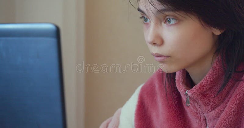60 images par seconde 4k d'une adolescente caucasienne devant un ordinateur portable à la maison. banque de vidéos