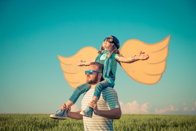 Happy kid playing with father outdoors in summer field. Travel and vacation concept. Imagination and freedom. Happy kid playing with father outdoors in summer field. Travel and vacation concept. Imagination and freedom