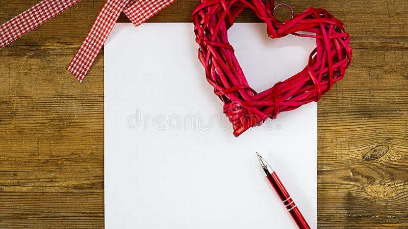 Imite encima de la hoja de papel limpia con la pluma roja, el corazón de la paja y la cinta blanca y roja de la contradanza en vi fotos de archivo Imite encima de la hoja de papel limpia con la pluma roja, el corazón de la paja y la cinta blanca y roja de la contradanza en vi fotos de archivo