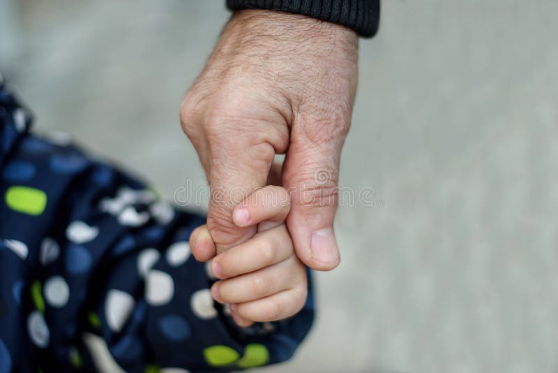 Immagine alta vicina di poca mano della tenuta del bambino del bambino di un parente senior: nonno o bisnonno immagine stock libera da diritti Immagine alta vicina di poca mano della tenuta del bambino del bambino di un parente senior: nonno o bisnonno immagine stock libera da diritti