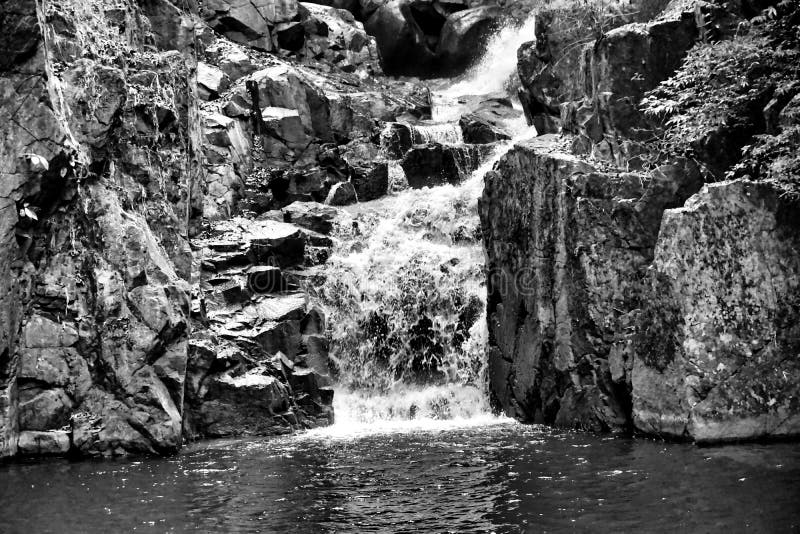 Immagine in bianco e nero di una piccola cascata fotografia stock