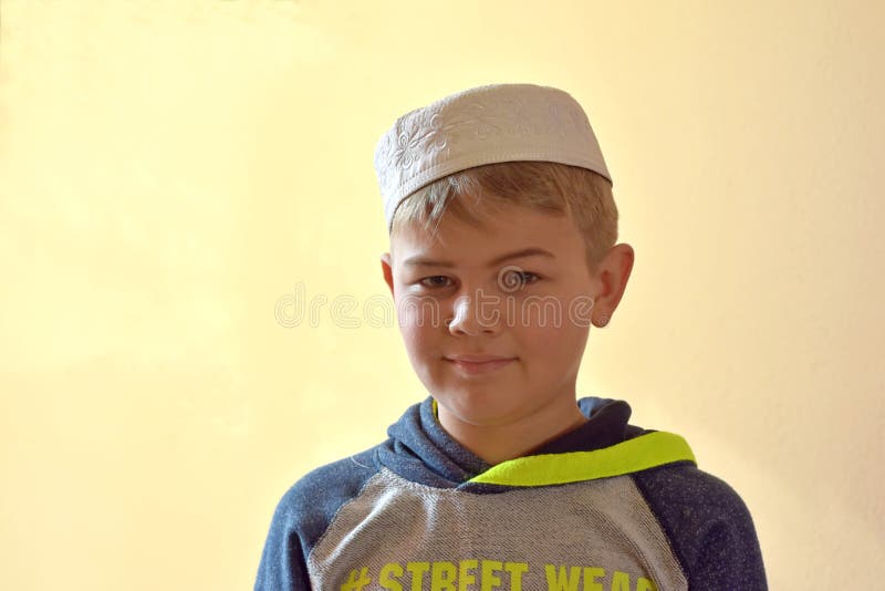 Immagine del ritratto del fronte pieno di giovane ragazzo musulmano sveglio che indossa il cappuccio islamico tradizionale del ca immagini stock Immagine del ritratto del fronte pieno di giovane ragazzo musulmano sveglio che indossa il cappuccio islamico tradizionale del ca immagini stock