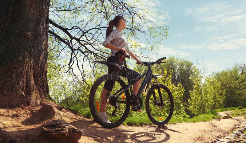 Immagine della donna con la bicicletta in un parco