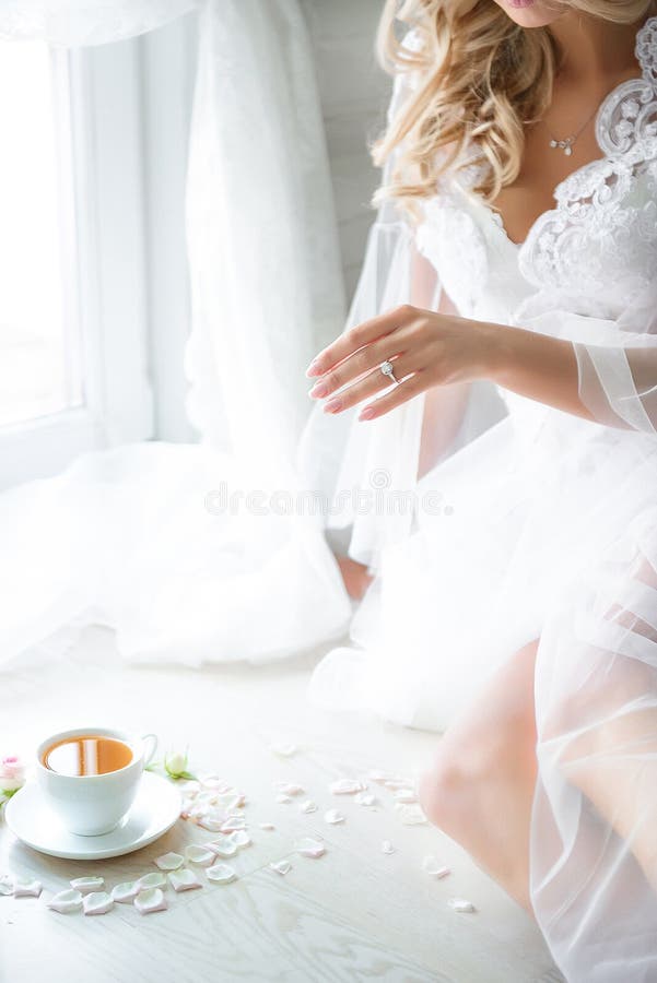 Immagine della mano bionda affascinante che tira verso la tazza di tè fotografie stock libere da diritti Immagine della mano bionda affascinante che tira verso la tazza di tè fotografie stock libere da diritti