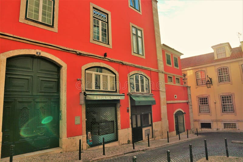 Immagine di fondo vecchia porta verde a telaio in una parete dipinta in corallo tipica dello stile del vecchio portugale di lisbon fotografia stock