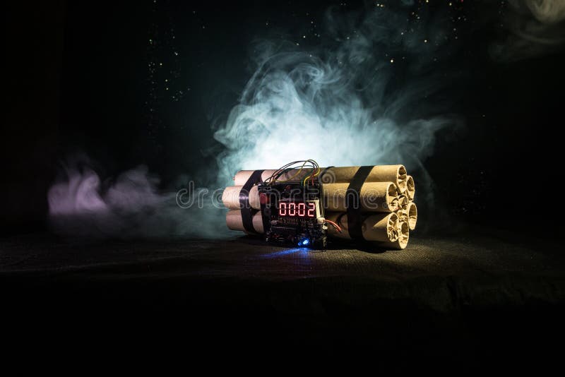 Immagine di una bomba a orologeria contro fondo scuro Temporizzatore che conta alla rovescia alla detonazione illuminata ad una l immagine stock libera da diritti Immagine di una bomba a orologeria contro fondo scuro Temporizzatore che conta alla rovescia alla detonazione illuminata ad una l immagine stock libera da diritti