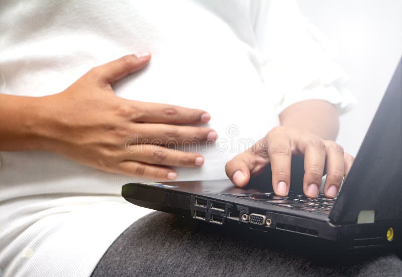 Immagine di una donna incinta dai 3 ai 6 anni il mese sta lavorando sui suoi affari. immagine stock