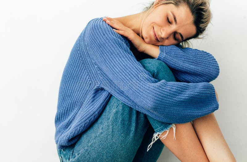 Immagine di una giovane donna tenera e bella seduta sul pavimento con espressione sognante a occhi chiusi, che sorride dall'amore fotografie stock Immagine di una giovane donna tenera e bella seduta sul pavimento con espressione sognante a occhi chiusi, che sorride dall'amore fotografie stock