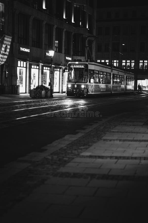 Immagine in scala di grigio verticale di un autobus notturno in città immagini stock libere da diritti